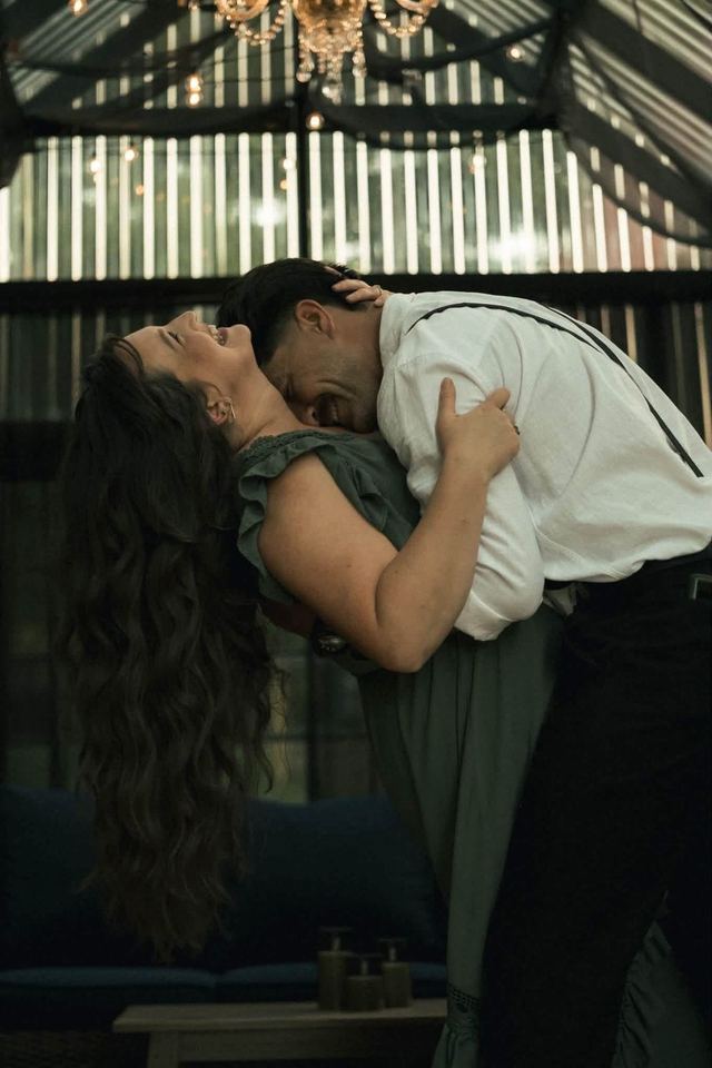 A couple sharing a dance and a dip inside The Glasshouse under the chandelier
