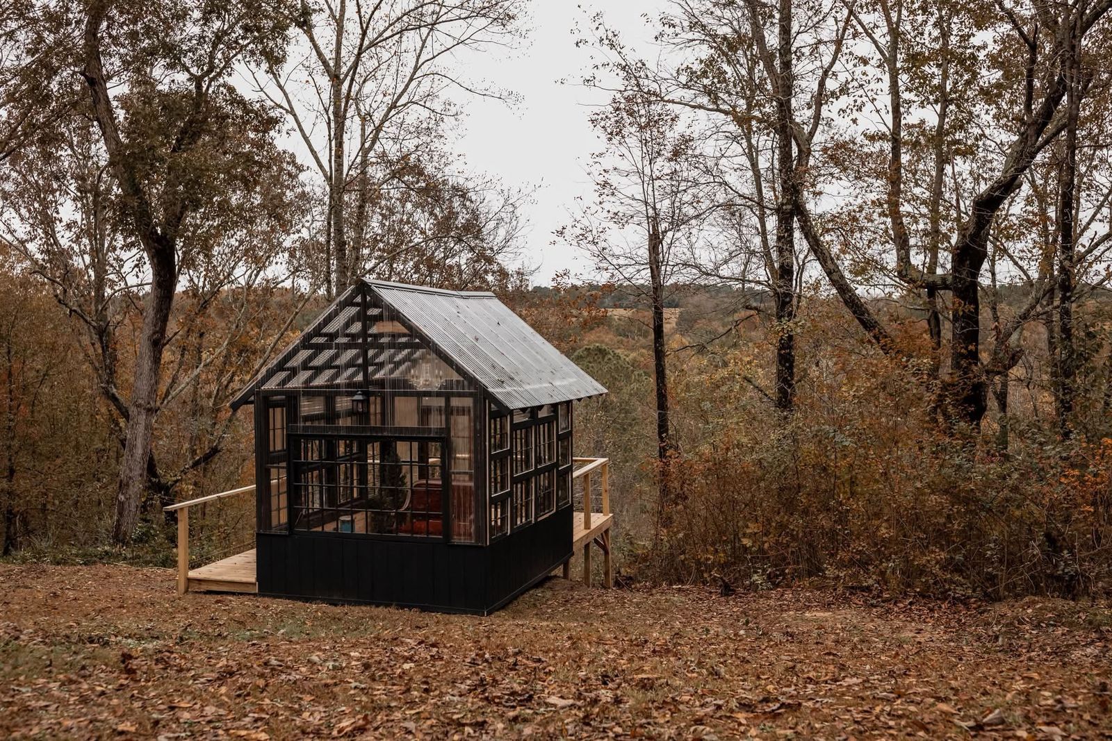 The Glasshouse and its deck among autumn trees