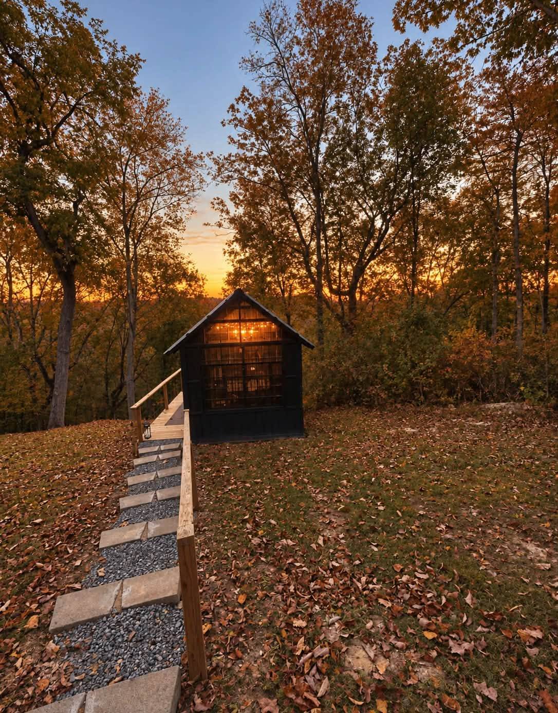 The Glasshouse glowing at sunset among autumn trees